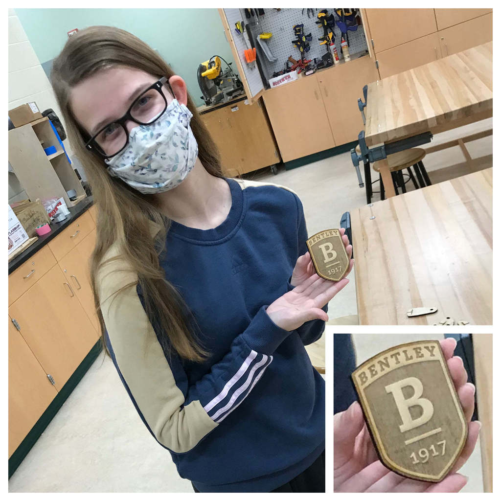 Julia Piercey is seen here after designing, cutting, and engraving this logo of Bentley University (her college destination) using the laser cutter.